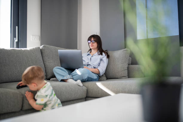 istock Multitasking woman working from home while taking care of her son. 2149736428