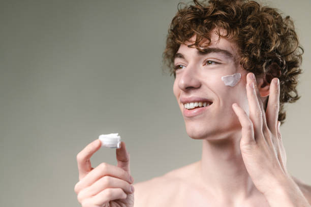 istock Young man applying a face cream and enjoying 2149737566