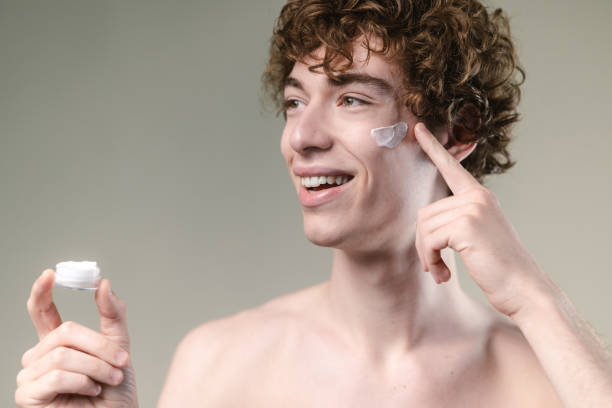 istock Young man applying a face cream and enjoying 2149737617