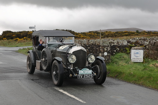 Caldbeck, England - April 13:  A 1928 Bentley Speed 6 leaves Caldbeck, Cumbria on April 13, 2024.  The car is taking part in the Flying Scotsman Rally, a free public-event.