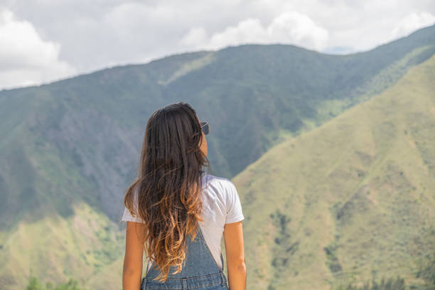 istock Young woman with a backpack on her back, looking at the horizon. 2149740458