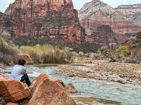Gender neutral teenager enjoys the peace and quiet amongst the majestic landscape of Zion National Park in Utah