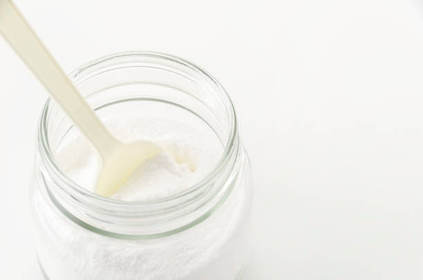 istock Baking soda in a Glass jar with a plastic spoon on white background 2149742128