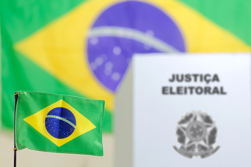 Brazilian flag in the foreground adorning the polling place, with a Brazilian electronic voting booth in the background. Elections in Brazil