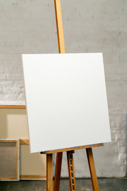 istock close up in an art studio there is a tripod with a large white and blank canvas next to a box 2149744306