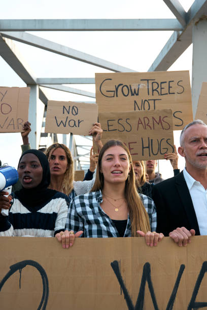 istock Multiracial people in protest with diverse group activist who demonstrate together shouting slogans. 2149744541