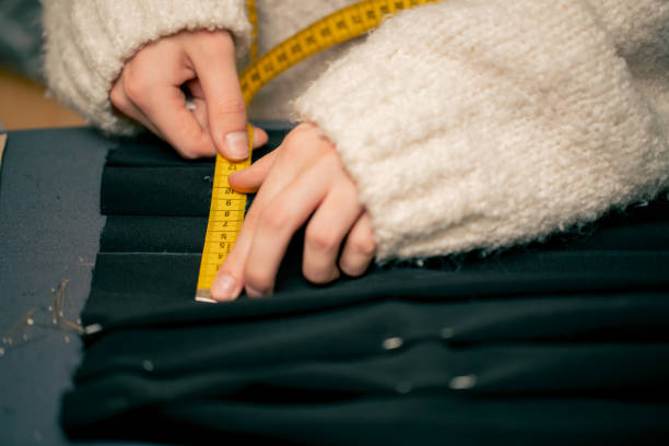 istock close-up in a sewing workshop seamstress measures on a black fabric where to pin 2149748672