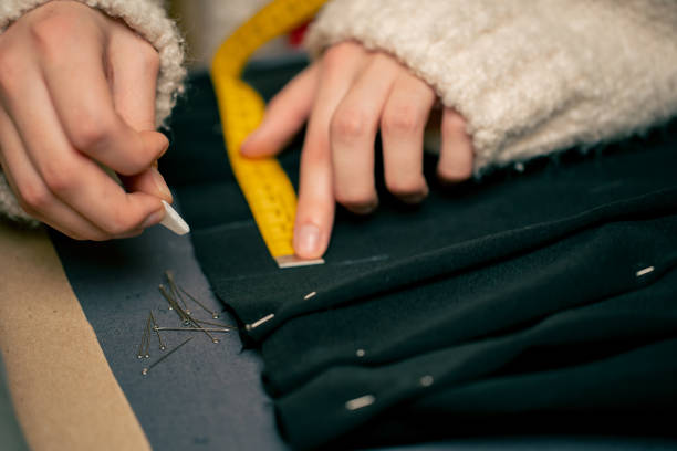istock close-up in a sewing workshop seamstress measures on a black fabric where to pin 2149748714