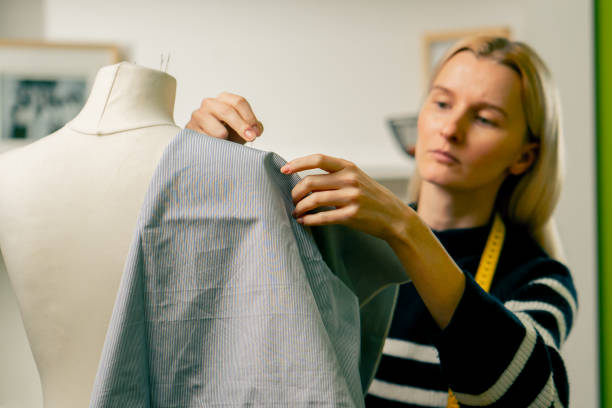 istock in sewing workshop seamstress works with a mannequin and pins blue fabric with a pin 2149749892