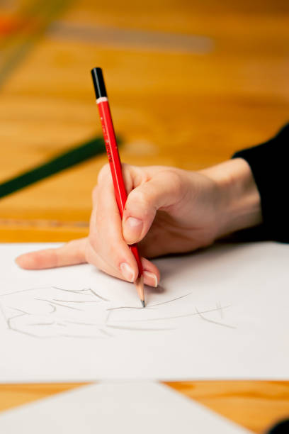 istock close-up in a sewing workshop woman's hand draws a sketch of future clothes 2149751020