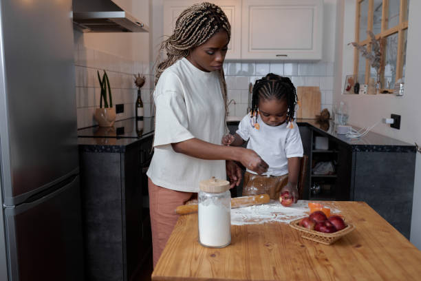 istock little awesome girl cooking biscuits with mom 2149751320