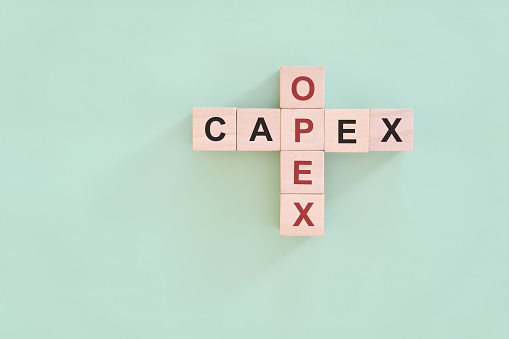 CAPEX versus OPEX concept. Crossword puzzle flat lay composition.