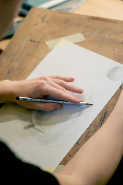 istock close-up in a sewing workshop the artist's hands draw a ball with a pencil on paper 2149751943
