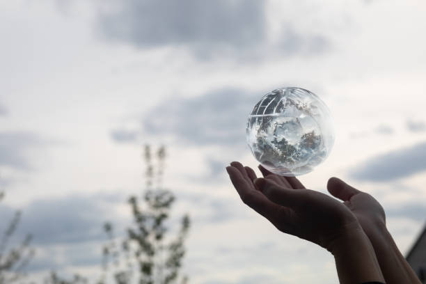 The concept of supporting the global world. Hands support a globe against the sky.