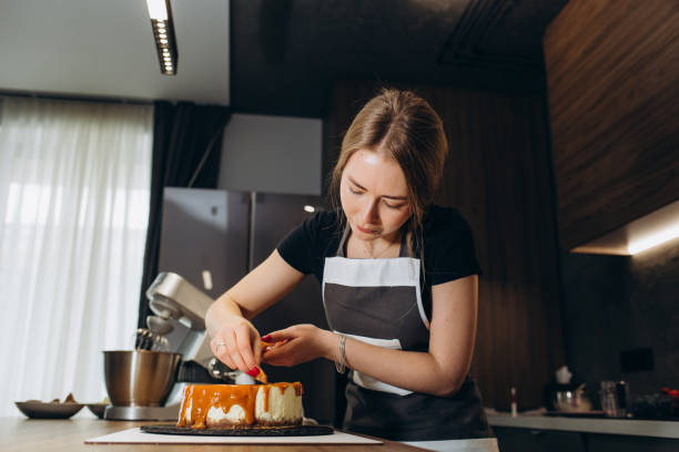 istock confectioner pours while looking at caramel cake in modern kitchen. 2149755038