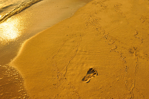 A footstep in the sand at the seaside. Reflection of someone was just there for a walk.