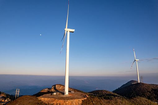 Wind turbines and terraced fields on the mountaintop at dusk