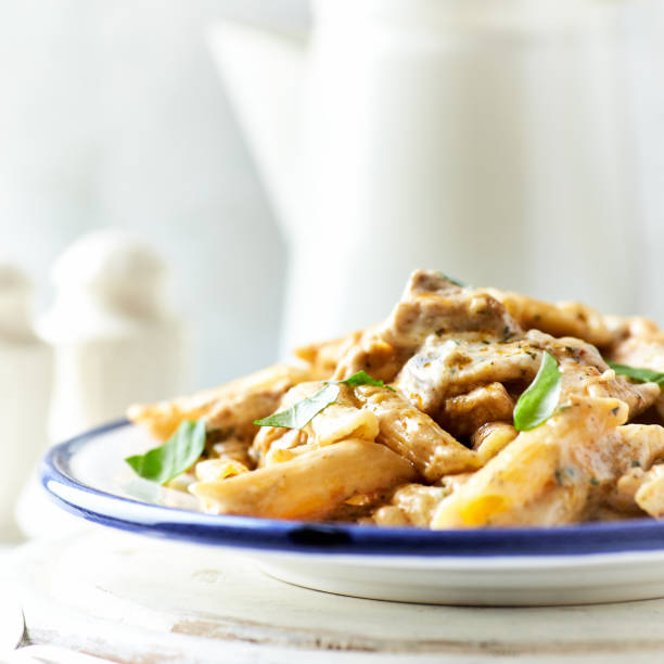 istock Penne Pasta baked with Meat on bright wooden Background. 2149767059