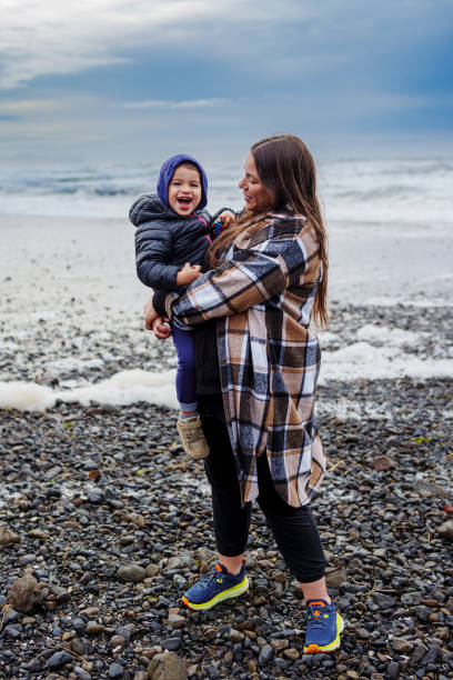 istock Young boy smiles while at the coast with his Mother 2149767426