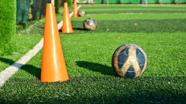 istock artificial green grass soccer field with training cone and ball 2149768422