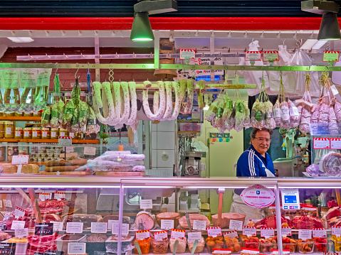 The City of Paris France on September 01, 2023: Butcher attending his shop on a street in the fourth  Arrondissement of Paris  France, with displays of products for sale