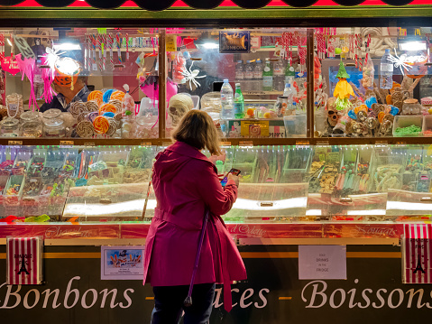 The City of Paris France on October 19, 2023:   A patron of a street convenience food vendor on her mobile device, in the Latin Quarter of Paris France