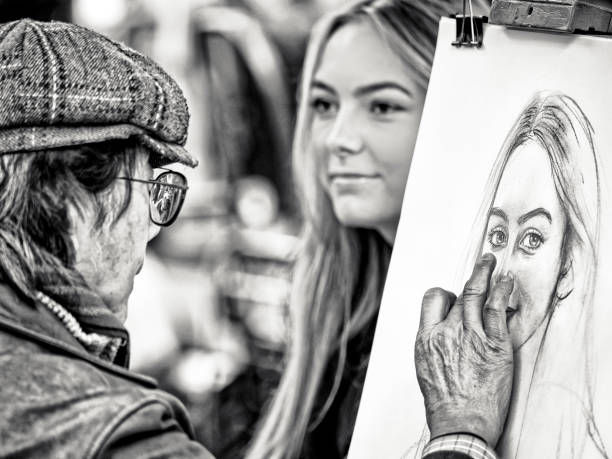 The City of Paris France on October 24, 2023:  Patrons sit for a classic portrait sketch by artists located in a public park in the Montmartre district of Paris France