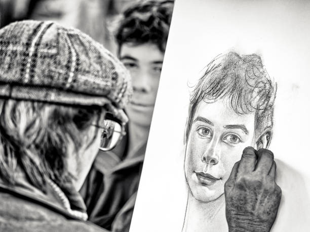 The City of Paris France on October 24, 2023:  Patrons sit for a classic portrait sketch by artists located in a public park in the Montmartre district of Paris France