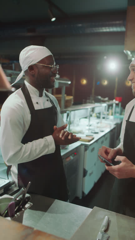 Two Chefs Greeting Each Other and Talking in Restaurant Kitchen