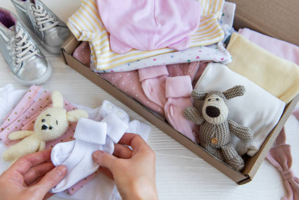 istock Women's hands collect children's clothes into boxes. 2149771123