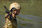 Special forces soldier with weapon take part in military maneuver.
