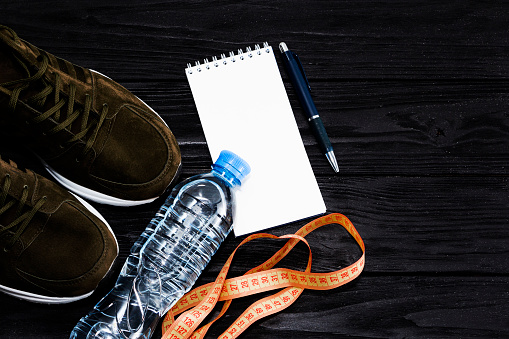 shoes and drinking water, for jogging, well-being and a notebook for recording calories. Diet, sports.