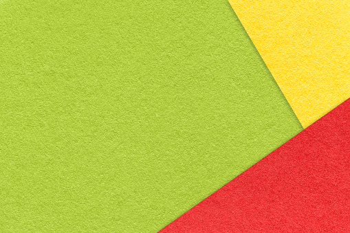 Texture of craft green color paper background with red and yellow border. Vintage abstract cardboard. Presentation template and mockup with copy space. Felt backdrop closeup.