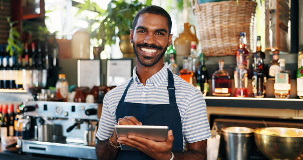 istock Tablet, black man and bartender smile for restaurant sales, alcohol service or career vocation. Portrait, job experience and African business owner with pride in drinks trade, supply chain or startup 2149772122