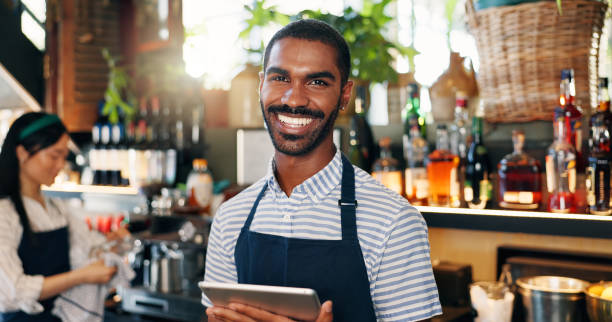 Tablet, black man and bartender smile for restaurant sales, alcohol service or career vocation. Portrait, job experience and African business owner with pride in drinks trade, supply chain or startup