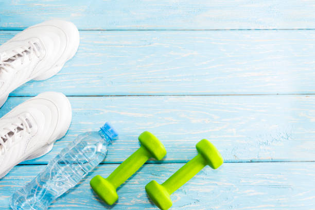 istock dumbbell sneakers on a bright background. Healthy lifestyle 2149772376