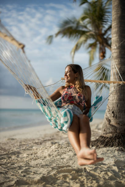 istock Happy woman spending her summer day in hammock on the beach. 2149773703