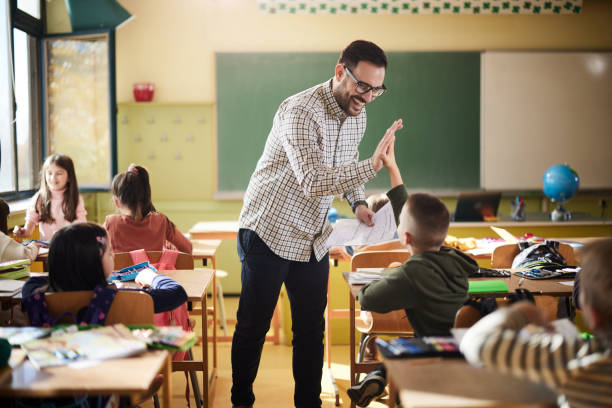 istock Happy teacher and schoolboy giving each other high-five on a class. 2149773953