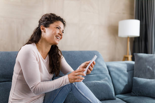 istock Happy woman using cell phone in the living room. 2149774233
