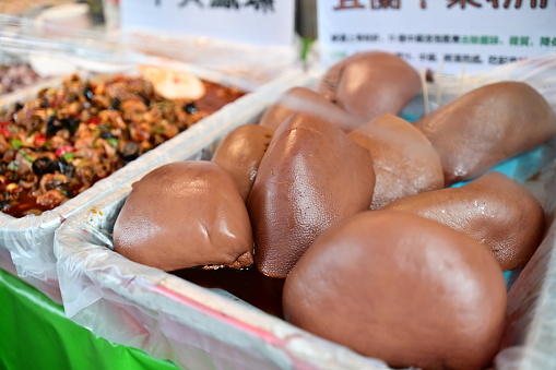At the traditional market food stalls, you can discover a diverse selection of grab-and-go foods. One favorite choice is the chilled tender pork liver shown in the photo.