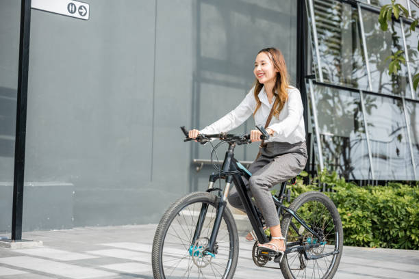istock young businesswoman with helmet riding bicycle go to office work 2149774679