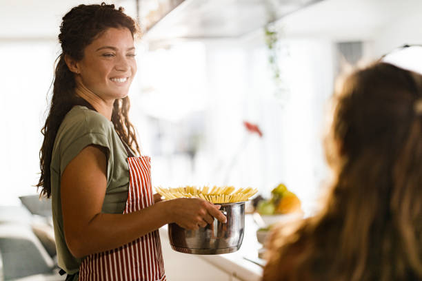 istock Happy mother and daughter making lunch in the kitchen. 2149774737