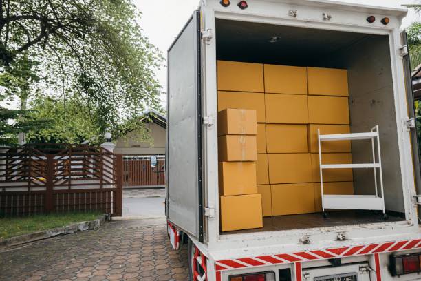 istock Logistic service outdoors, Open car trunk carrying moving cardboard boxes. White delivery van for house relocation. Transporting items scene. Moving Day Concept. 2149775156
