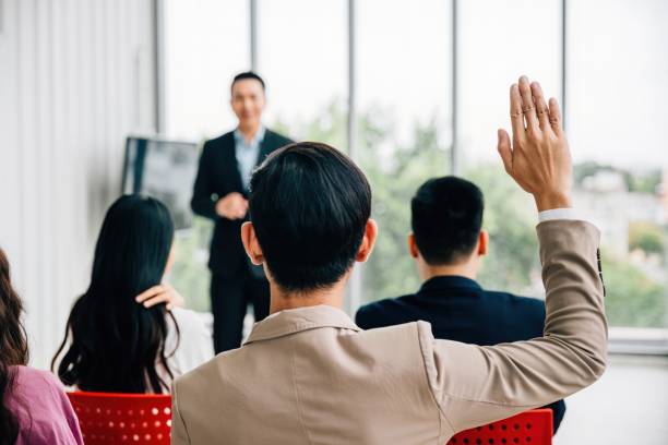 istock At a conference, hands are raised for questions, underlining the active participation of the audience. A diverse group collaborates in a workshop or seminar, emphasizing teamwork and discussion. 2149775188