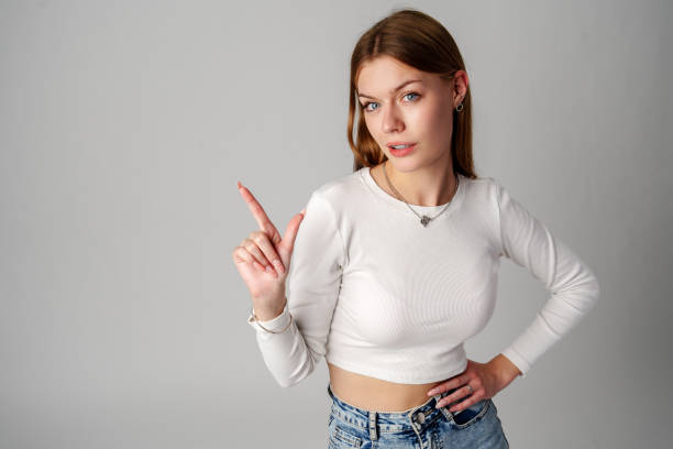 istock Young Woman Gesturing With Her Finger While Speaking Against a Gray Background 2149777278
