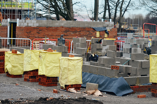 Red bricks and concrete blocks delivered on construction site and ready for bricklayers
