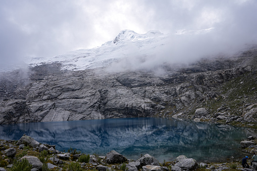Discover the ethereal beauty of Huaraz, Peru, with these captivating landscape photographs. Behold a mountain lake shrouded in mist, its turquoise waters contrasting against the majestic backdrop of a snow-covered peak. Experience the enchantment of nature's tranquility captured in this stunning Andean vista.