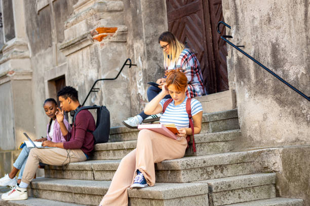 istock Diverse group of students sitting on stairs takling and learning together. 2149782480