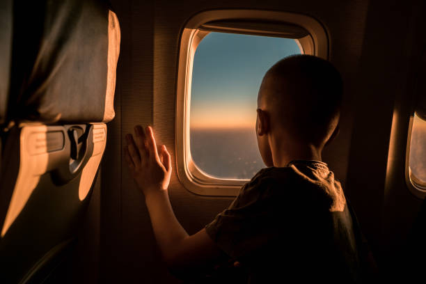 istock Rear view of a boy in airplane looking through the window. 2149782720