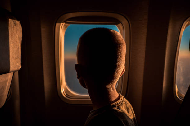 Boy contemplating the view from an airplane window